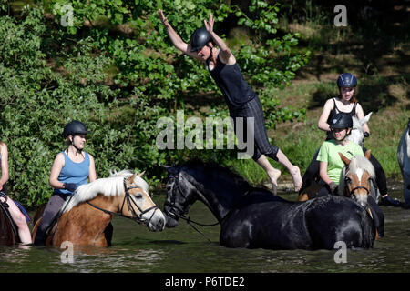 Oberoderwitz, donna jumping dal suo cavallo in un lago Foto Stock