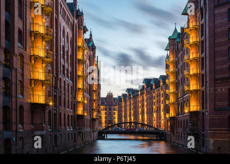 Germania, Amburgo, HafenCity. Magazzini storico sul canal Wandrahmsfleet nella Speicherstadt trimestre al crepuscolo, Sito Patrimonio Mondiale dell'UNESCO. Foto Stock