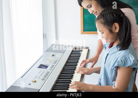 Un insegnante di musica con ragazza giovane pupillo alla lezione di pianoforte Foto Stock