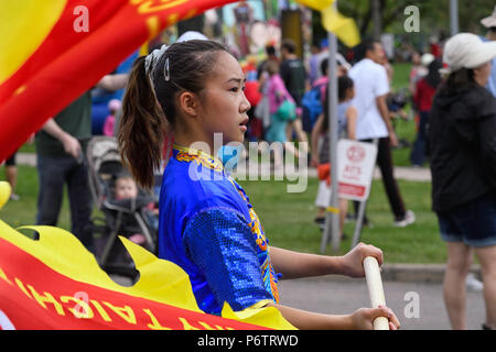 Giovane ragazza asiatica sventola una bandiera a Calgary in Canada del giorno in festa a Chinatown Foto Stock