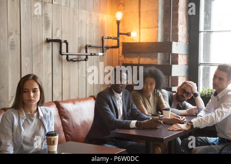 Sconvolto respinto ragazza ignorando la gente acclamava lei in cafe Foto Stock