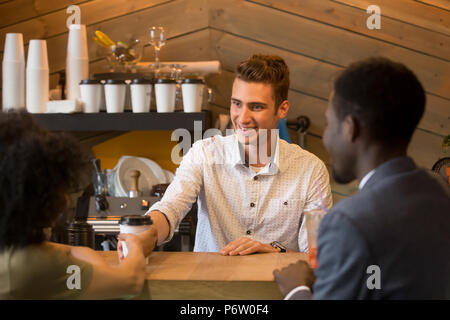 Caucasian barista che serve caffè alla ragazza nera durante la data Foto Stock