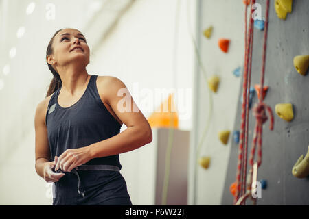 Fitness, sport estremo, clibbing, femmina e uno stile di vita sano concetto - una giovane donna con il preparato ponendo le mani a piscina palestra arrampicata parete Foto Stock