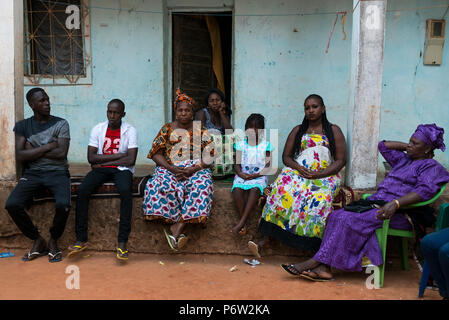 Bissau, Repubblica di Guinea Bissau - 31 Gennaio 2018: Famiglia sittting davanti alla loro casa al Cupelon de Cima quartiere nella città di Bissa Foto Stock