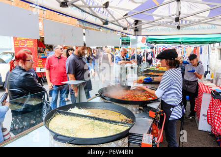 Vista lungo stallo di mercato la vendita di cibo caldo a Le Weekend evento francese, Sandwich, Regno Unito. Diversi grandi cauldrons con il cibo, la gente in attesa di essere serviti. Foto Stock