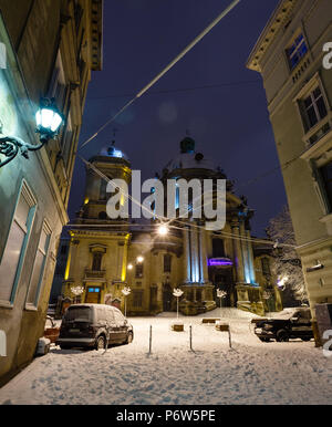 LVIV, Ucraina - Febbraio 04, 2018: bella notte paesaggio invernale nel centro della città di Leopoli. Chiesa dominicana. Alcuni lens flare lampade flrom trattati Foto Stock