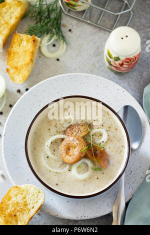 Zuppa di purea di funghi con crostoni di pane in una ciotola di close-up su una lavagna luminosa dello sfondo. Menù dietetici. Il concetto di mangiare sano. Foto Stock