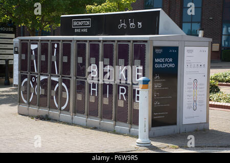 Self-service Brompton noleggio bici struttura presso la stazione ferroviaria nella città di Guildford, Surrey, Regno Unito Foto Stock