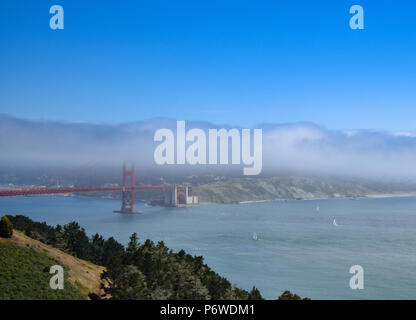 Un sottile strato di nebbia ostacola le vedute del centro cittadino di San Francisco e il Golden Gate Bridge in una fresca e soleggiata giornata d'estate. Foto Stock