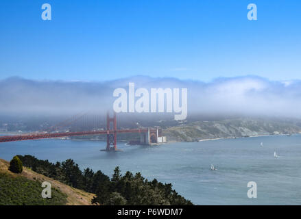 Un sottile strato di nebbia ostacola le vedute del centro cittadino di San Francisco e il Golden Gate Bridge in una fresca e soleggiata giornata d'estate. Foto Stock