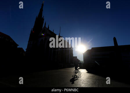 Würzburg, Germania. 03 Luglio, 2018. Un ciclista che va oltre la piazza del mercato di fronte alla Marienkapelle durante il sorgere del sole. Credito: Karl-Josef Hildenbrand/dpa/Alamy Live News Foto Stock