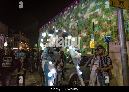 Gerusalemme, Israele. 2 Luglio, 2018. Un ballerino con vestiti incandescente esegue presso la vecchia città durante il 2018 Festa delle luci. Questo è il decimo anniversario del festival, che attira centinaia di migliaia di visitatori della città vecchia di Gerusalemme, che è illuminato da molte sculture di luce e mostra Credito: Yagil Henkin/Alamy Live News Foto Stock