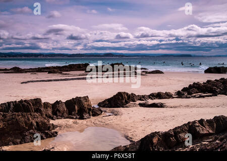 Surf colpendo le rocce su una spiaggia Foto Stock