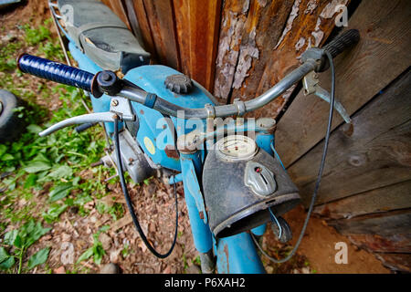 Un vecchio abbandonato cavalletto di motoveicoli nei pressi di un recinto nel villaggio Foto Stock