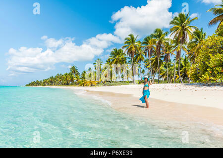 Canto de la Playa, Saona Island, Parco Nazionale Orientale (Parque Nacional del Este), Repubblica Dominicana, Mar dei Caraibi. Bella donna su una spiaggia orlata di palme (MR). Foto Stock