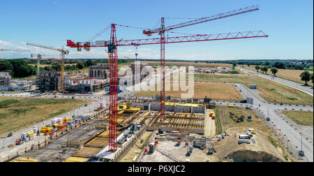 Sito in costruzione di gru e le conchiglie per case nuove, sullo sfondo la preparazione dell'area per il parcheggio di autovetture, foto aerea, realizzata con d Foto Stock