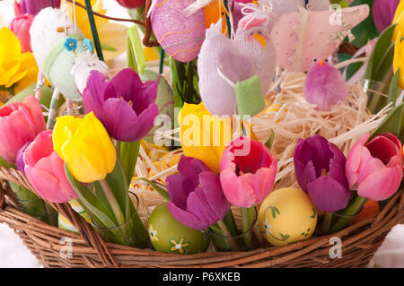Bellissimi fiori di primavera in un cestello con decorazioni di Pasqua Foto Stock