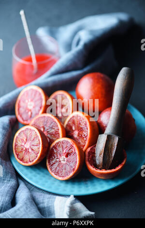 Rosso Arancio siciliano pezzi sulla piastra blu closeup Foto Stock