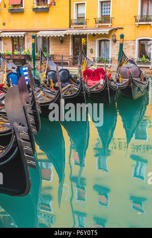 Venezia, Veneto, Italia. Colorate gondole attraccate riflettendo nell'acqua. Foto Stock