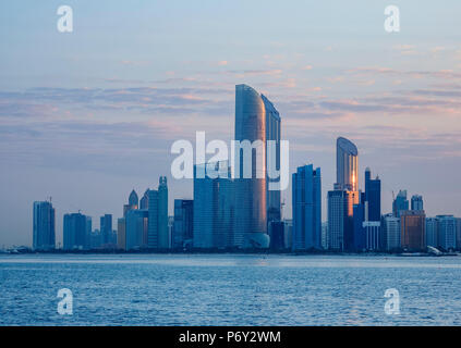 Skyline del centro città a sunrise, Abu Dhabi, Emirati Arabi Uniti Foto Stock