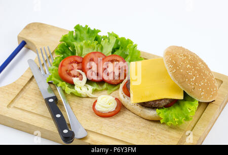 Fatta in Casa hamburger con lattuga, pomodoro, formaggio, carne di manzo e patatine fritte poste su sfondo di legno , freschi e saporiti burger sfondo, Foto Stock