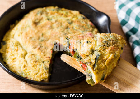 Frittata fatta di uova e verdure su un tavolo di legno. Foto Stock