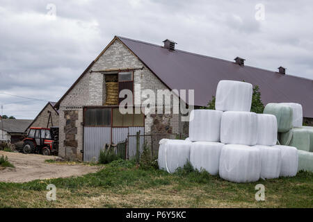 Impilati come una piramide,balle di insilato, avvolto in una membrana.il cibo per le mucche in inverno, vicino la stalla per le mucche.Farm in Podlasie, Polonia. Foto Stock