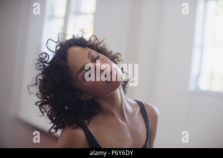 Calma giovane ballerino femmina collo stiramento in studio di danza Foto Stock