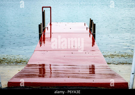Cemento rosso dock sul lago sotto la pioggia - Fort Lauderdale, Florida, Stati Uniti d'America Foto Stock