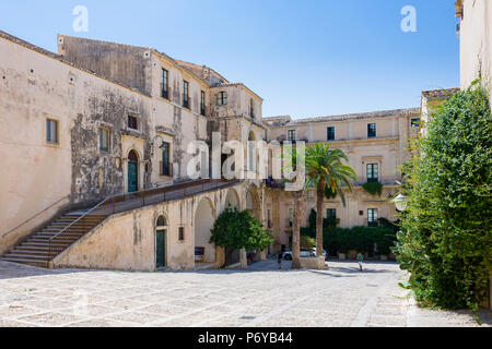 Il pittoresco cortile interno con palme di Noto, Sicilia Foto Stock