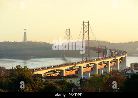 25 de Aprile ponte (simile al Golden Gate bridge) attraverso il fiume Tago e Cristo Rei (Cristo Re) sulla riva sud del fiume, la sera. Lisbona, Portogallo Foto Stock