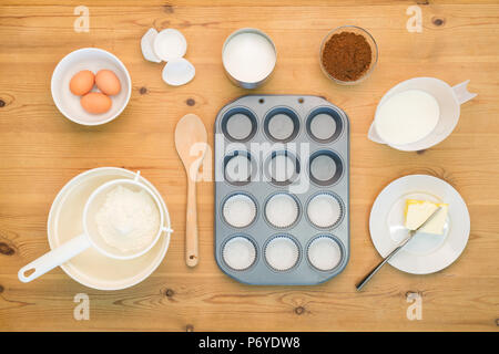 Tettuccio piatto disposizione laici di Cup Cake rendendo gli ingredienti e le attrezzature su un tavolo da cucina. Foto Stock