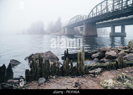 Vecchio, abbandonato ponte ferroviario in misty luce della sera Foto Stock