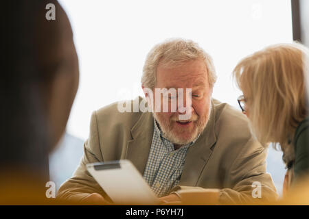 Senior business persone utilizzando la tavoletta digitale in riunione Foto Stock