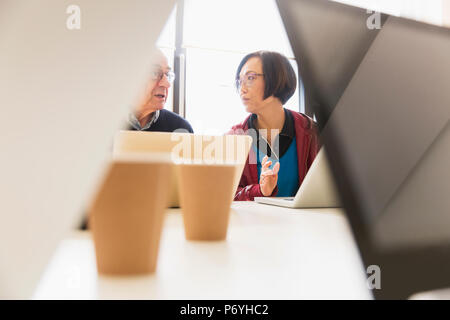 La gente di affari di parlare, utilizzando computer portatili in sala conferenza incontro Foto Stock