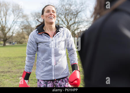 Donna sorridente boxe in posizione di parcheggio Foto Stock