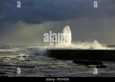 Mare tempestoso onde di oltre il molo e il faro con bella luce prima pioggia. Ave foce, a Vila do Conde, il nord del Portogallo. Foto Stock