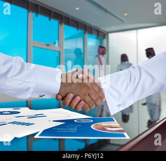 Arabia imprenditori arabi si stringono la mano e fare un accordo o ad una trattativa in una sala riunioni Foto Stock