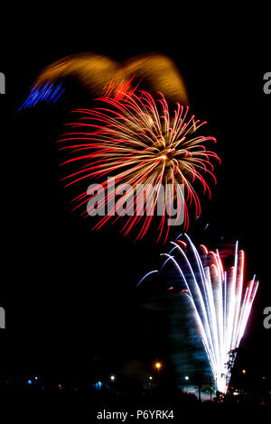 Fuochi d'artificio burst con vento rendendo il display sembrano avere le orecchie del cane con rucola sentieri. Foto Stock