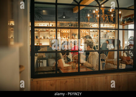 Sorridente amici ordinare bibite all interno di un bar alla moda Foto Stock