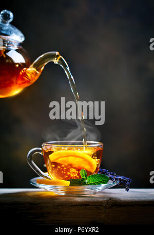 Procedimento preparazione del tè,cerimonia del tè. Tazza di appena infuso di tè nero,calda luce morbida. Foto Stock