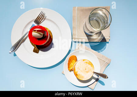 Cappuccino con caffè e torta di fragole e un bicchiere di acqua. Foto Stock