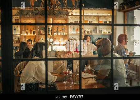 Diversi giovani amici avente le bevande insieme a un bar alla moda Foto Stock