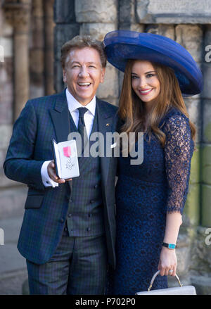 La televisione e la radio presenter Ross King, con la moglie Brianna, dopo aver ricevuto il suo (membro dell'ordine dell'Impero Britannico) MBE per i servizi di radiodiffusione, le arti e la carità dalla Regina Elisabetta II durante una cerimonia di investitura presso il Palazzo di Holyroodhouse di Edimburgo. Foto Stock