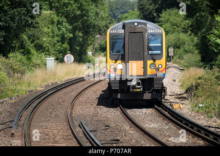 In ritardo a causa di limiti di velocità in tempo caldo, South Western Railway 444 Classe commuter train south bound tra Londra Waterloo e Portsmouth attraverso Foto Stock