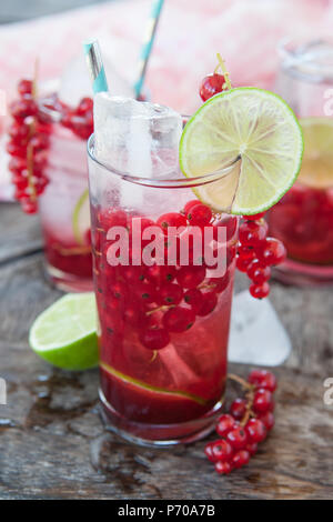 Cocktail nel bicchiere alto con ribes rosso e calce Foto Stock