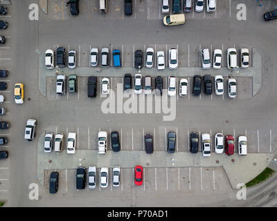 Vista aerea di un gran numero di autovetture di differenti marche e colori in piedi in un parcheggio nei pressi del centro commerciale in un modo caotico. Parcheggio d Foto Stock