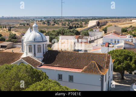 Vista da una collina sulla chiesa di Nossa Senhora dos Martires in Castro Marim, Algarve, Portogallo, circondato da case. Orizzonte del paese e un bl Foto Stock