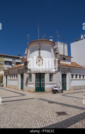 Street con il tipico acciottolato. Vista sul corner house, dove è pubblico spa. Architettura tradizionale. Azzurro cielo. Vila Real de Santo Antonio Foto Stock