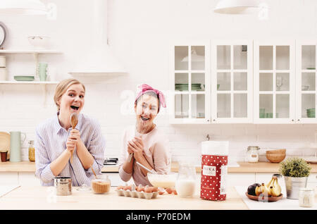 Due amici allegro cucinare insieme dolci e cantare. Foto Stock